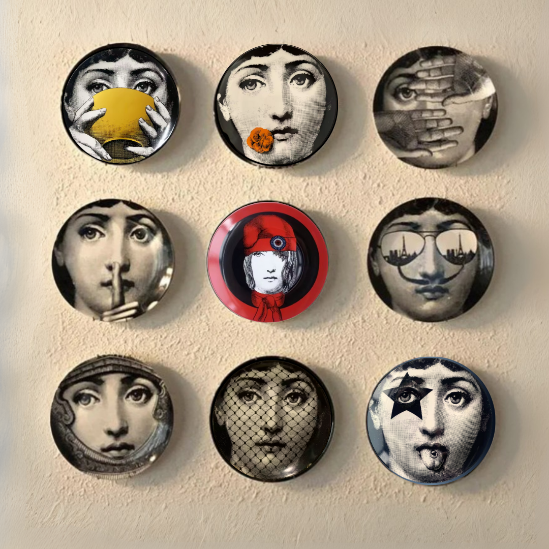 Set of decorative ceramic plates with artistic face designs on a beige wall.