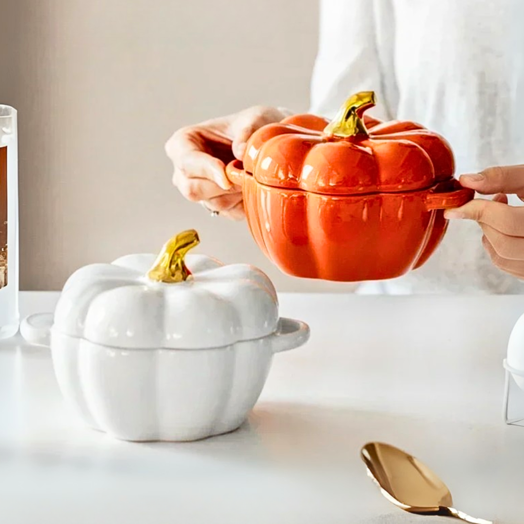 Orange and white pumpkin-shaped ceramic soup bowls on a modern kitchen with a person holding the orange bowl.