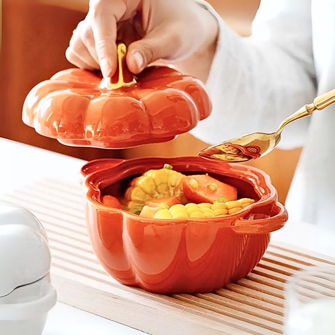 Person using an orange pumpkin-shaped bowl to serve food on a wooden surface.