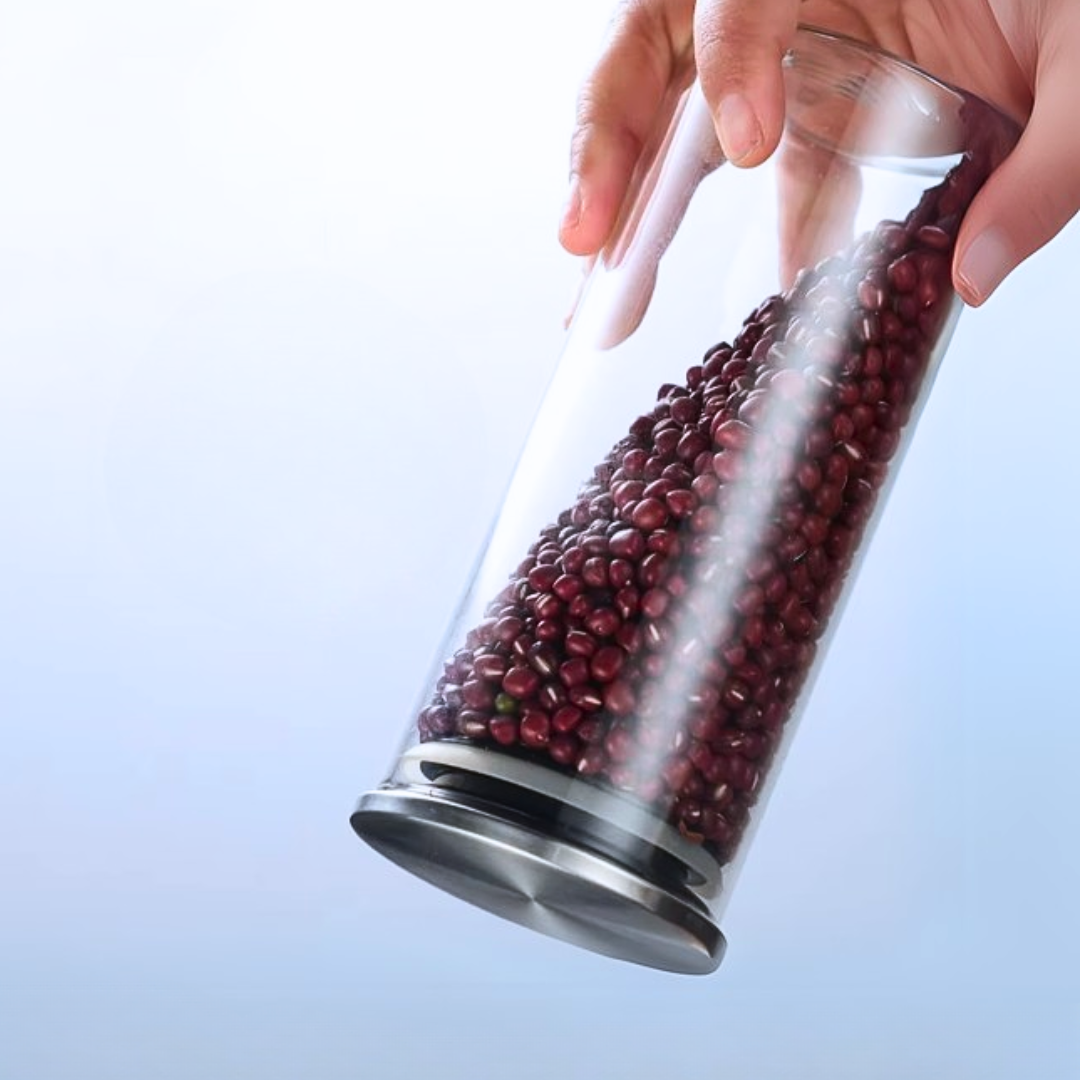 Clear glass container with red beans held by a hand.