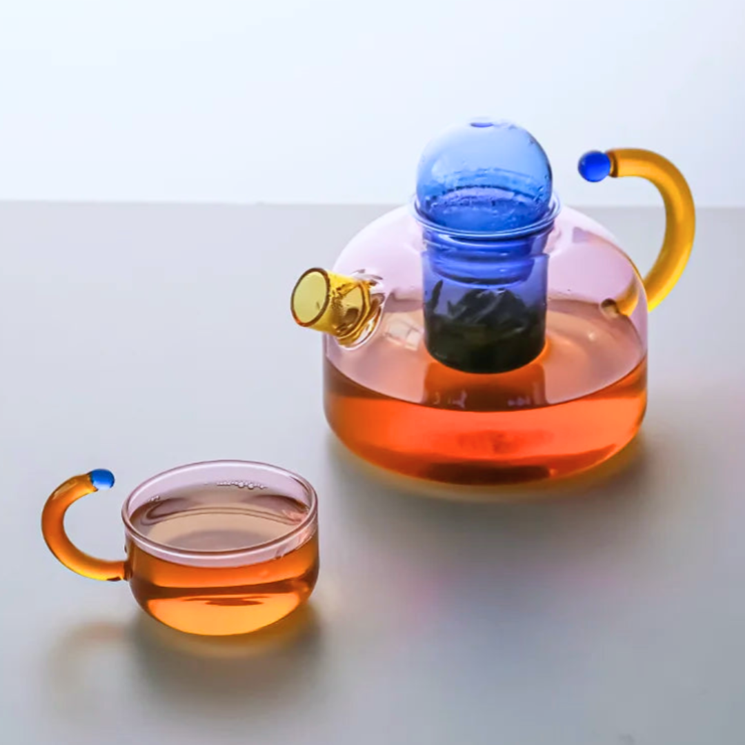 Glass teapot and cup with colorful handles