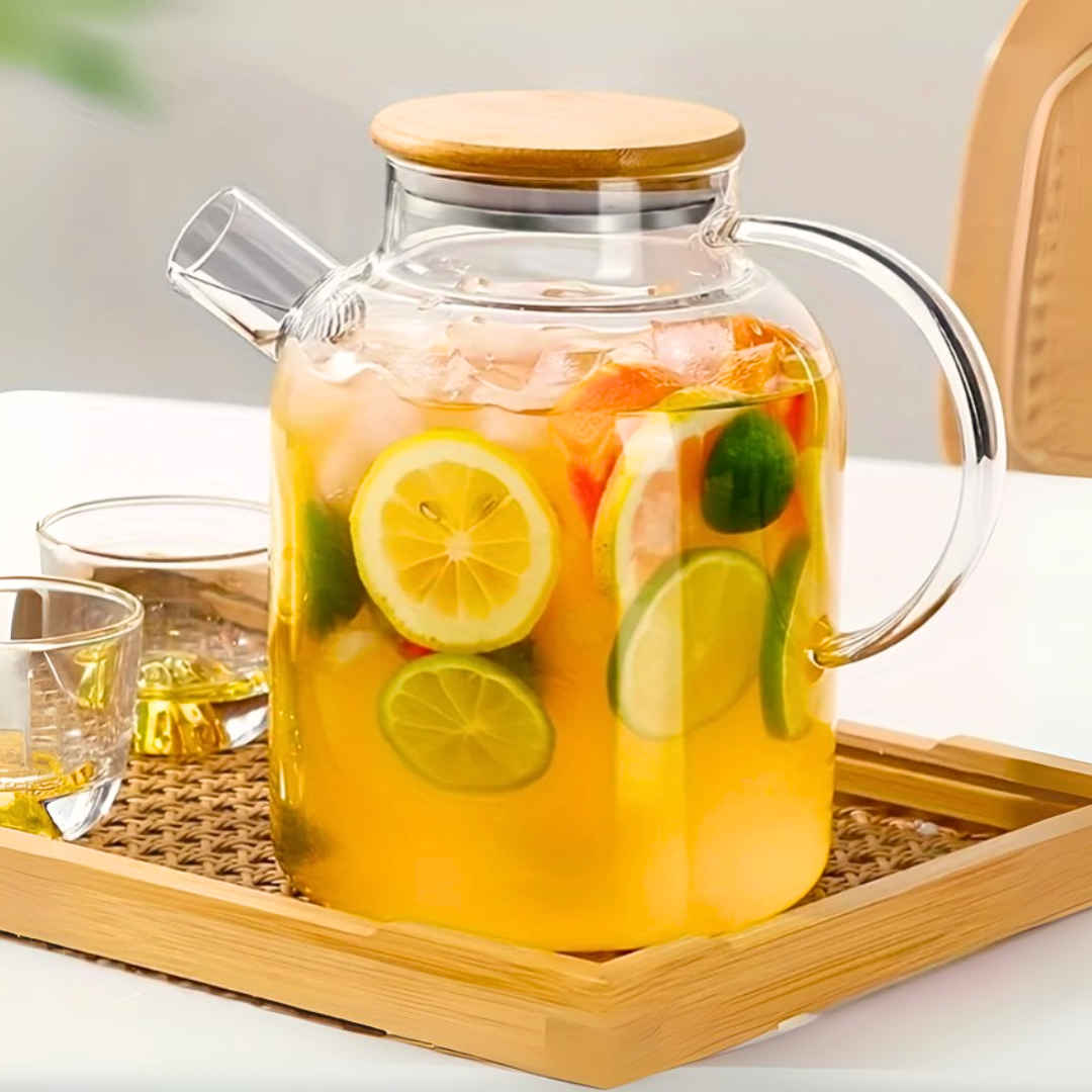 Clear glass kettle with lemon and lime slices on a wooden tray